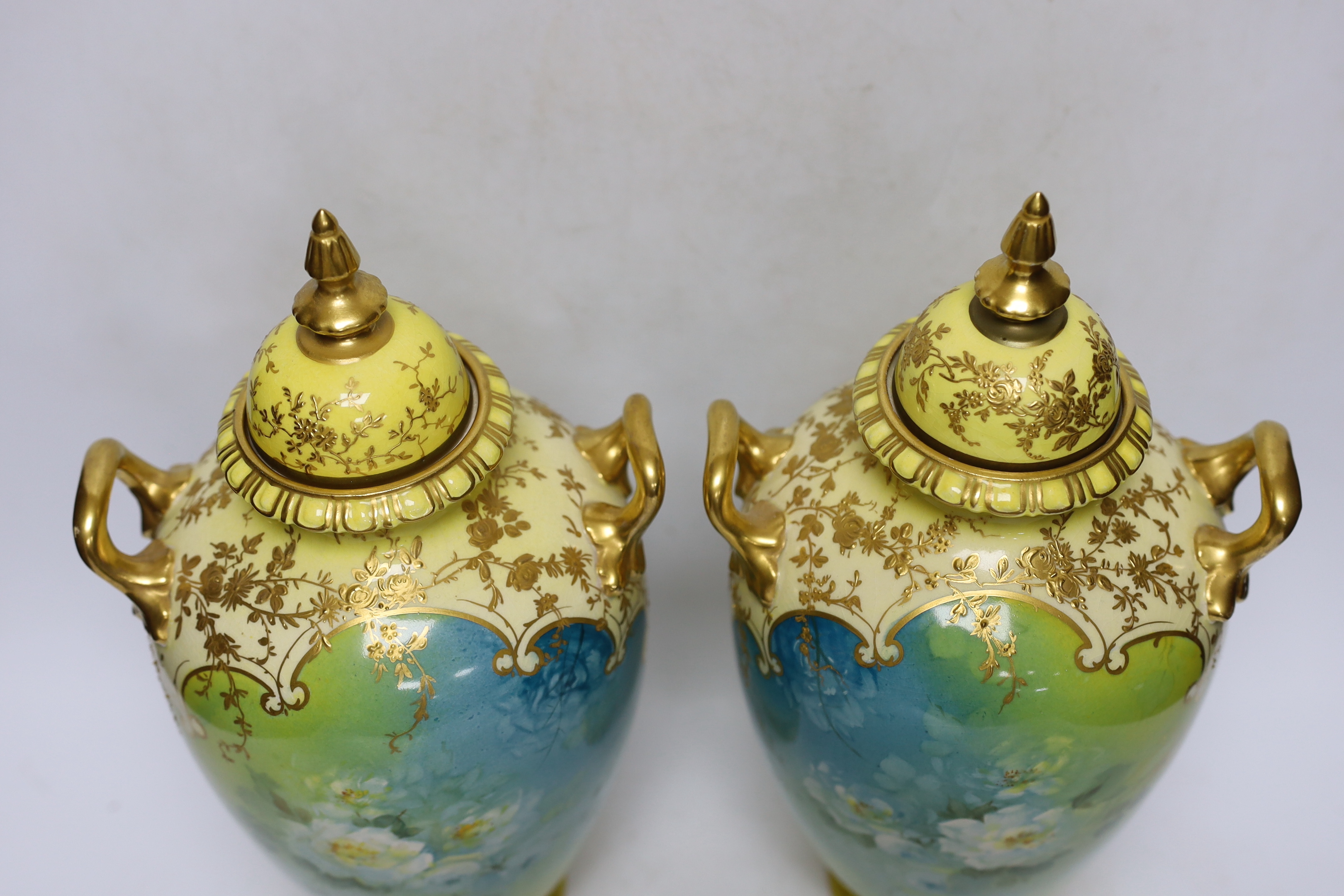 A pair of Royal Bonn flower painted earthenware vases and covers, 34cm